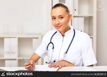 Young female doctor in white uniform at workplace