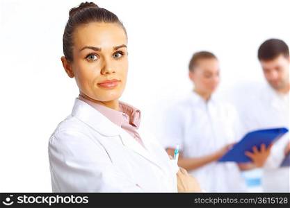 Young female doctor in white uniform with collegues on the background