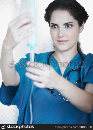 Young female doctor looking at an iv drip