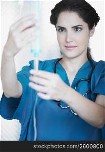 Young female doctor looking at an iv drip