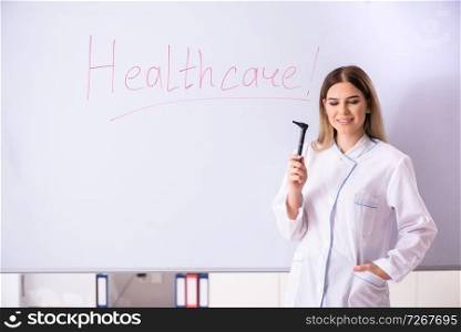 Young female doctor standing in front of the white board 