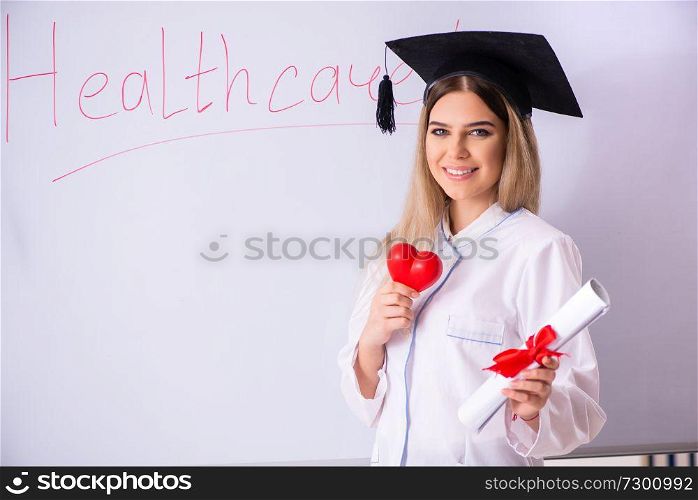 Young female doctor standing in front of the white board