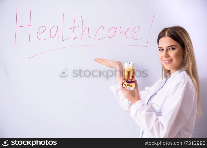 Young female doctor standing in front of the white board 