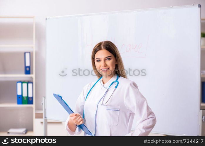 Young female doctor standing in front of the white board 