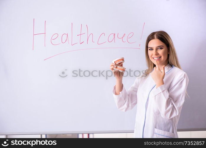 Young female doctor standing in front of the white board 