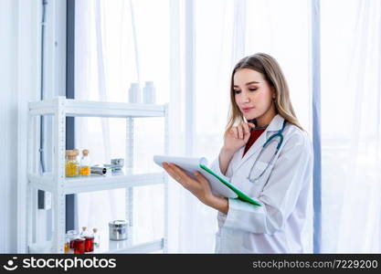 young female doctor therapeutic advising with positive emotions hold clipboard up with smiley face very good on wooden table in Hospital background