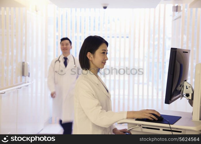 Young female doctor using the computer in the hospital, Beijing, China