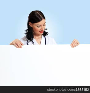 Young female doctor with a banner. Portrait of happy successful young female doctor holding blank banner