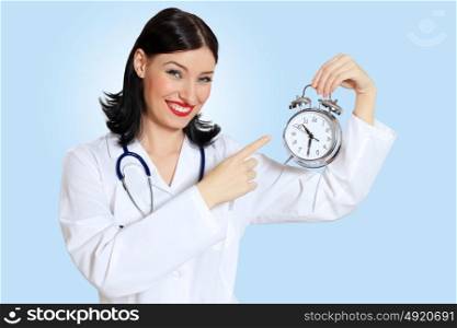 Young female doctor with clocks. Portrait of happy successful young female doctor holding clocks