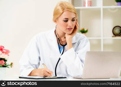 Young female doctor working in hospital office. Medical and healthcare concept.. Young female doctor working in hospital office.