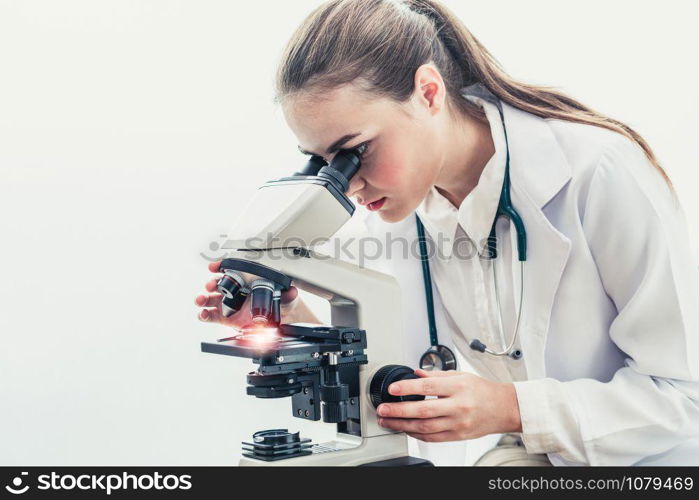 Young female doctor working using microscope in hospital laboratory. Medical and medicine technology research and development concept.