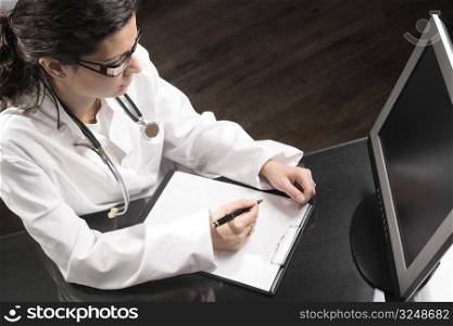 Young female doctor works on her desk.