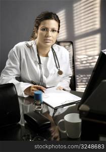 Young female doctor works on her desk.