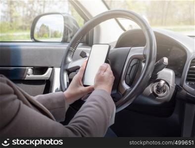 Young female driver using touch screen smartphone and gps navigation in a car