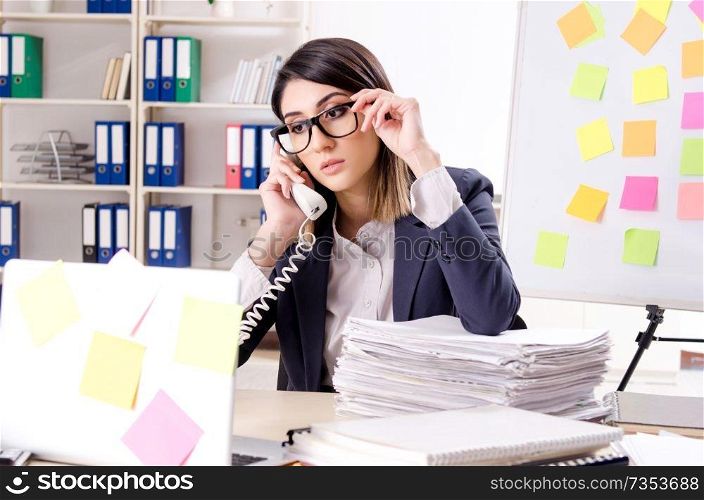 Young female employee in conflicting priorities concept 