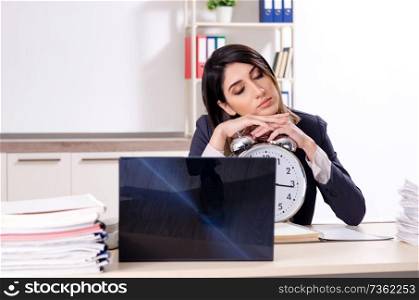 Young female employee in time management concept 
