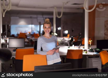 young female entrepreneur working on digital tablet in night office