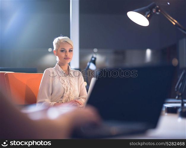 young female entrepreneur working on laptop computer in late night startup office