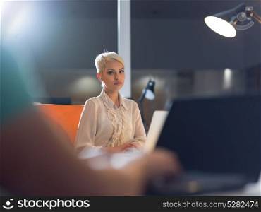 young female entrepreneur working on laptop computer in late night startup office