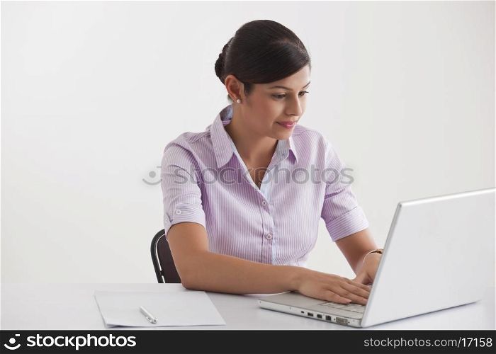Young female executive using laptop