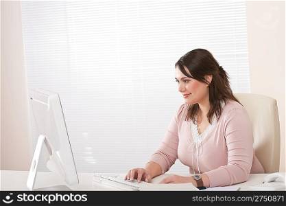 Young female executive working with computer at modern office