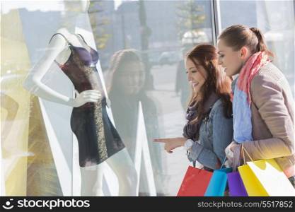 Young female friends window shopping