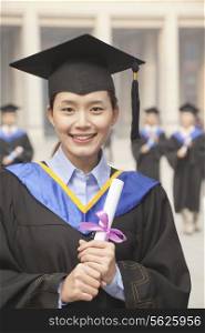 Young Female Graduate Holding Diploma, Portrait