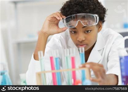 young female laboratory scientist working at lab with test tubes
