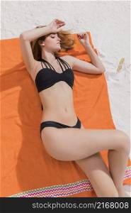 young female lying orange towel