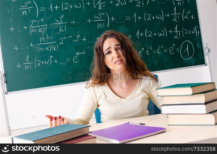 Young female math teacher in front of chalkboard  