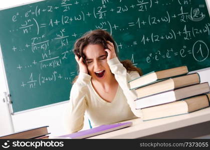 Young female math teacher in front of chalkboard  