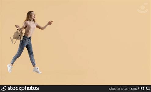 young female model with hand bag jumping