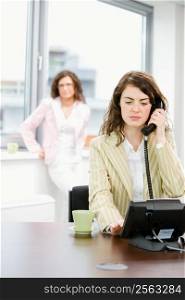 Young female office workers - businesswoman receiving phone calls.
