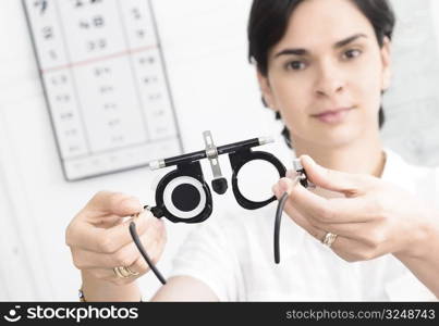 Young female optometrist with an universal messbrille in hand.