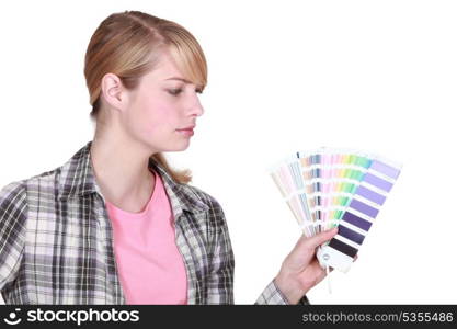 young female painter holding color chart