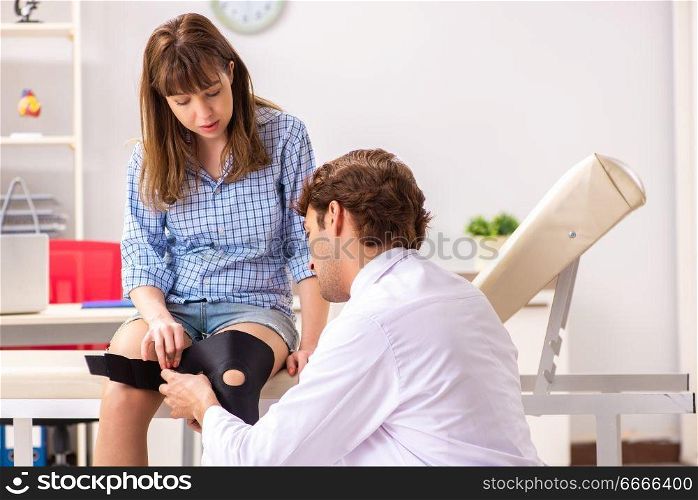 Young female patient visiting male doctor traumatologist 