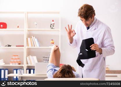 Young female patient visiting male doctor traumatologist 