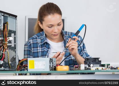 young female pc technician fixing a computer