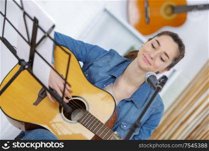young female playing a guitar