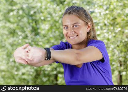 young female runner stretching arms before running