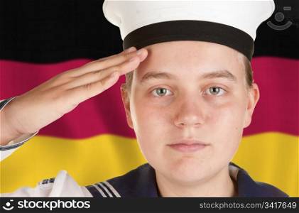 young female sailor saluting in front of german flag