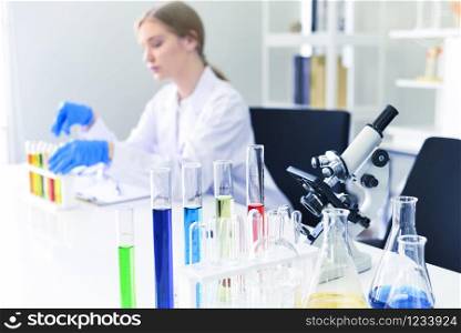 Young female scientist doing some research working conduct experiments and microscope in modern laboratory / Scientists in lab biochemistry genetics forensics microbiology and test tube