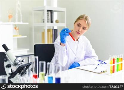 Young female scientist doing some research working conduct experiments and microscope in modern laboratory / Scientists in lab biochemistry genetics forensics microbiology and test tube female doctor