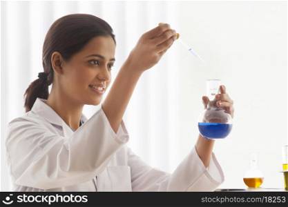 Young female scientist experimenting in lab