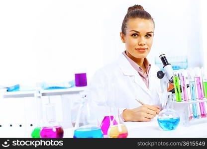 Young female scientist working with liquids in laboratory