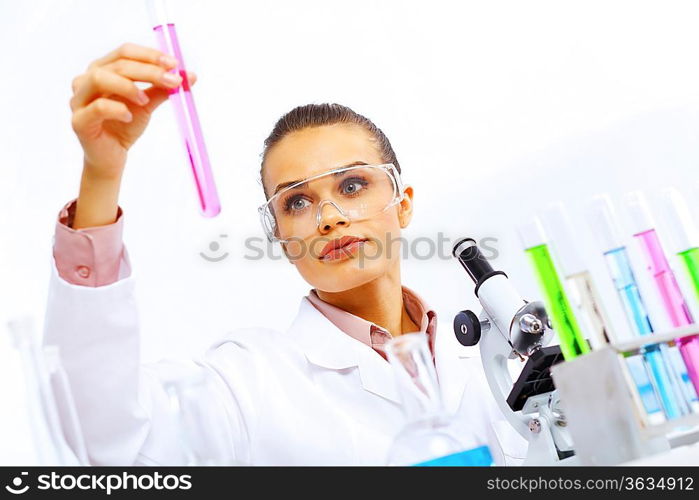 Young female scientist working with liquids in laboratory