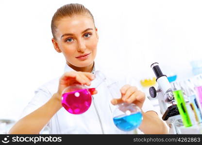 Young female scientist working with liquids in laboratory