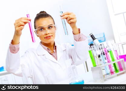 Young female scientist working with liquids in laboratory