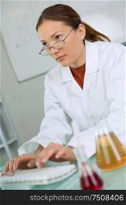 young female scientist working with liquids in laboratory