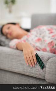 Young female sleeping with pack of pills